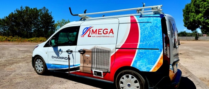 Omega Air Conditioning company vehicle parked in gravel lot with blue sky and trees